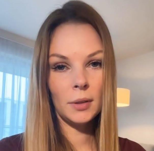 Małgorzata Tomaszewska podczas prowadzenia programu telewizyjnego, dynamiczna poza, uśmiechnięta, w tle elementy studia.