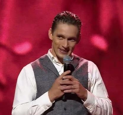 Filip Gurłacz w trakcie występu na scenie telewizyjnego show, dynamiczna poza.