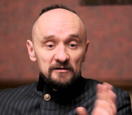 Dynamiczna scena teatralna w dramatycznym oświetleniu, symbolizująca innowacyjny styl reżyserski Jana Klaty.
