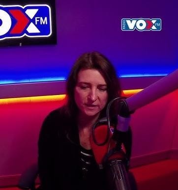 Renata Dąbkowska w trakcie dynamicznego występu na scenie, śpiewająca z pasją do mikrofonu, w świetle reflektorów.