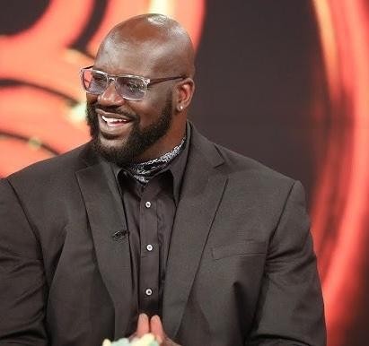 Shaquille O'Neal wykonujący potężny wsad do kosza w koszulce Los Angeles Lakers.