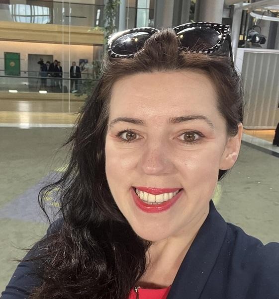 Dominika Ćosić aktywnie uczestnicząca w dyskusji lub konferencji, symbolizująca jej zaangażowanie w politykę międzynarodową i publicystykę.