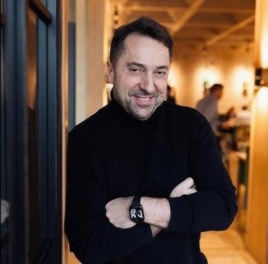 Marcin Miller z optymistycznym uśmiechem, prezentujący swoją pozytywną postawę podczas występu medialnego.
