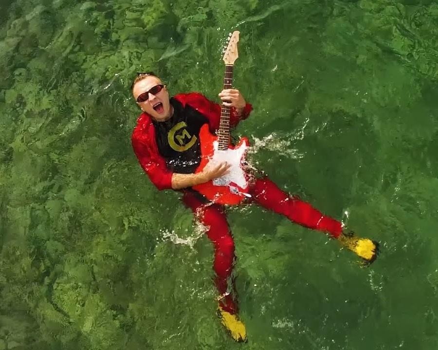 Czadoman podczas energicznego występu na scenie, śpiewający do mikrofonu.